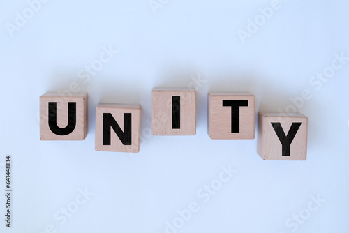 unity word on block cubes, collaboration or team idea, random wooden block cubes with unity text, randomly ordered blocks, banner concept