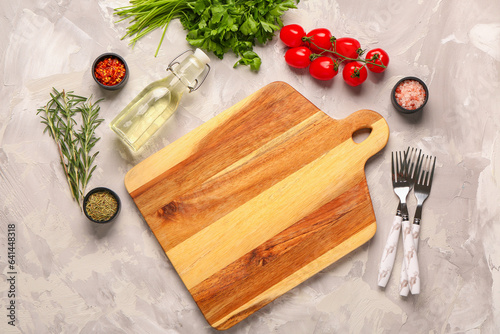 Composition with wooden cutting board, fresh spices and tomatoes on light background photo