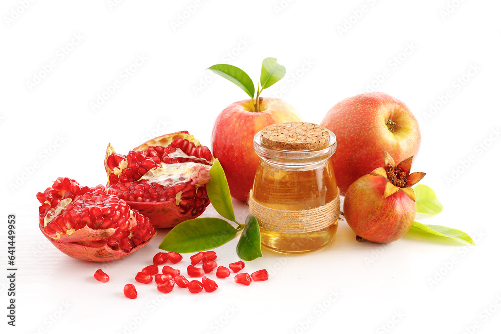 Pomegranates, apples and honey on white background, traditional food of