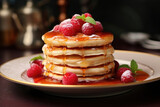A pile of pancakes with raspberries and sauce