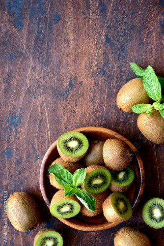 Fresh kiwi in a wooden bowl. Top view with copy space.