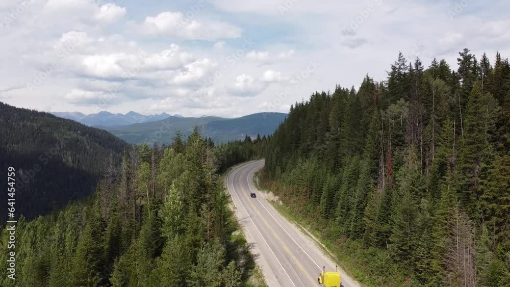 Cars Driving on Highway Road - Still Video - Rocky Mountains British Columbia Canada. Cars passing by on a scenic road with trees and mountains surrounding them. Cars Driving on Highway Road - Still Video - Rocky Mountains British Columbia Canada. Cars passing by on a scenic road with trees and mountains surrounding them.