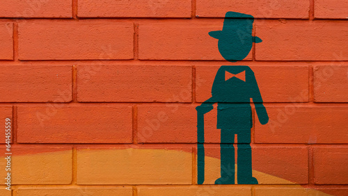 Red-orange interior and exterior walls or brightly colored cement walls with cartoon images of men can be used as a background or wallpaper in front of the bathroom.