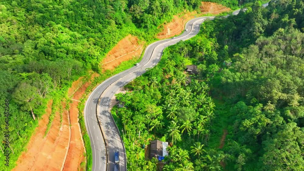 Drone flight over the road's gradual ascent through the rainforest-covered hills. As it climbs higher, the vistas become even more awe-inspiring. The panoramic views of Nature's artistry. Thailand.
Drone flight over the road's gradual ascent through the rainforest-covered hills. As it climbs higher, the vistas become even more awe-inspiring. The panoramic views of Nature's artistry. Thailand.