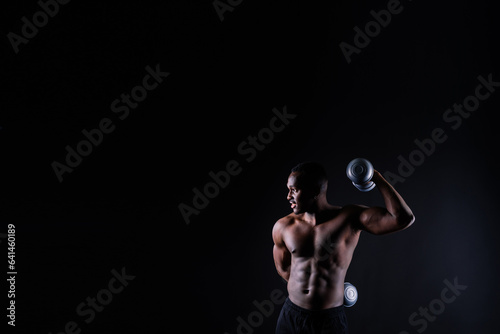 Close-up muscles of african american handsome body builder naked torso on black studio background photo