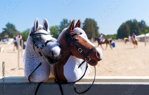 Hobby horses are waiting for the riders. Equestrian sports. Equestrian equipment. Sports. Summer. The sun. Banner. Outdoors. Close-up
