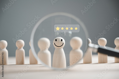 Magnifying glass emotion face icon in HR search. Talent management concept. Human resources officer seeks leader and CEO. HR manager hand selects an employee. Leader stands out from crowd.