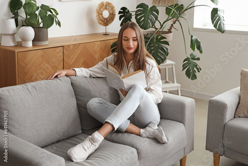 Young woman reading book on...