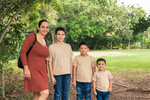 latin family smiling at camera in green field