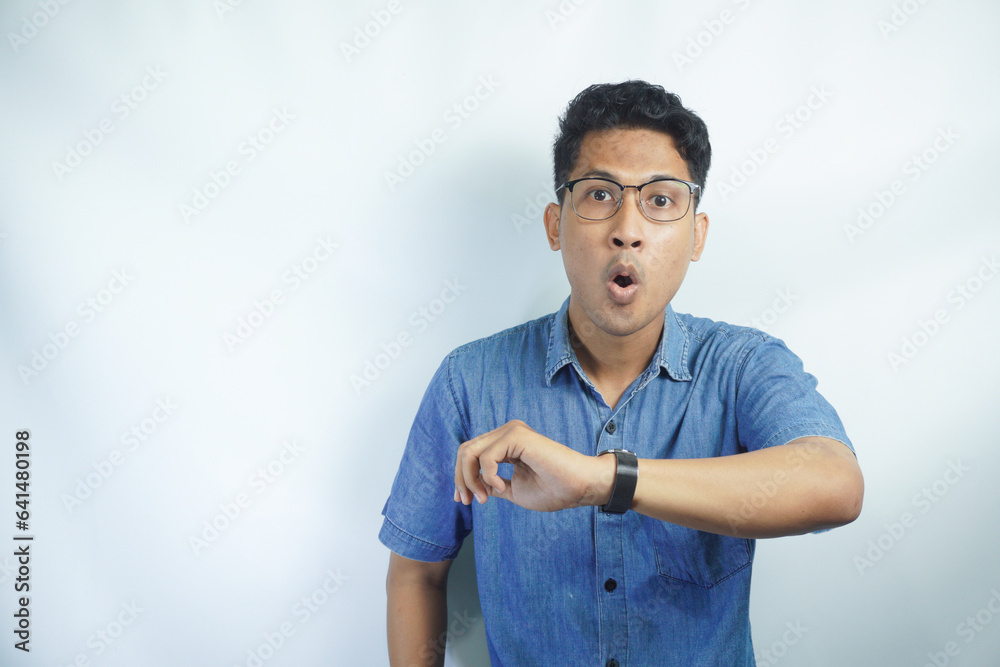 Portrait of funny Asian man shocked worried to see his wrist watch, late time concept Portrait of funny Asian man shocked worried to see his wrist watch, late time concept