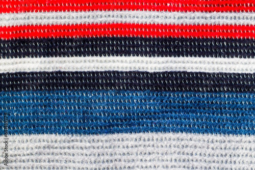 Hand knitted wool blanket background with red, blue, white stripes