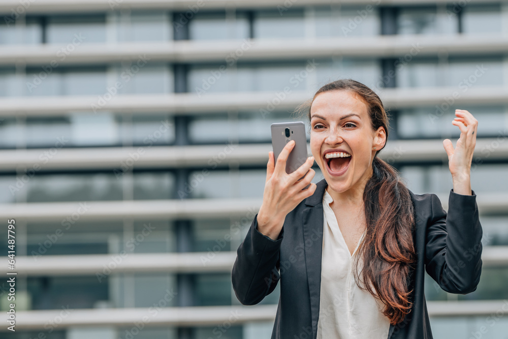 excited happy business woman celebrating looking at mobile phone excited happy business woman celebrating looking at mobile phone