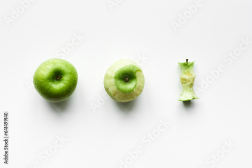 Three stages of apple: just bought ripe green apple, peeled apple and apple core isolated on white background  photo