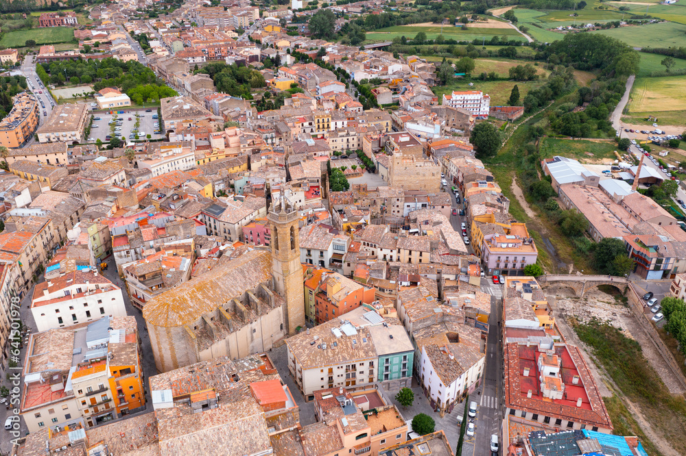 Aerial view of central area of Catalan town of La Bisbal d Emporda with terracotta tiled roofs of residential houses, square Plaza Mayor, fortified episcopal residence and Santa Maria church, Spain