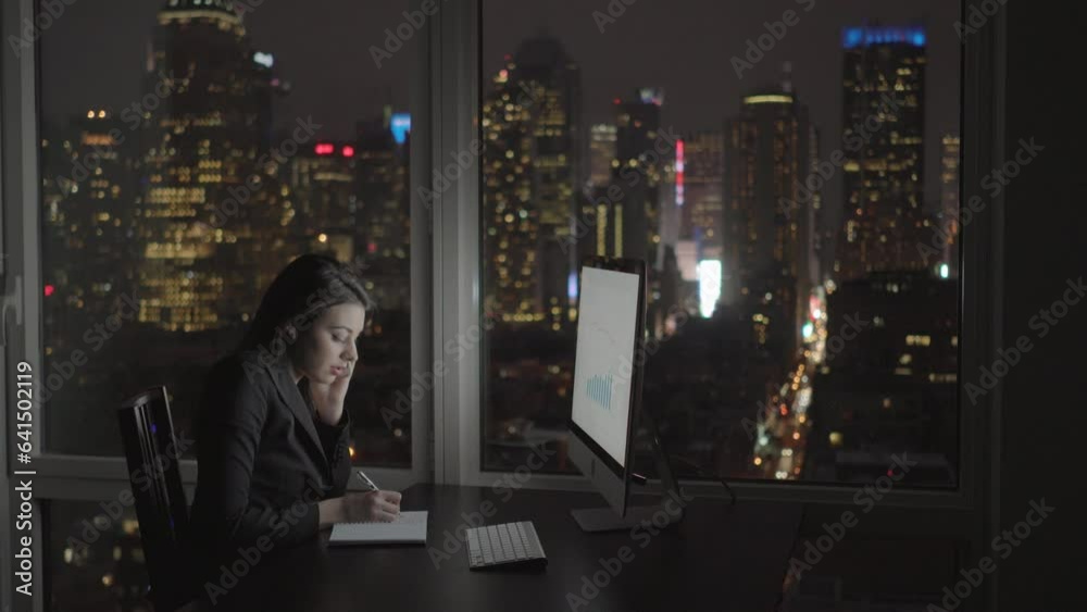 Young Confident Woman Working in Modern Office on Computer Desk At Night Young Confident Woman Working in Modern Office on Computer Desk At Night