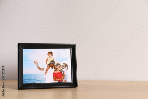 Frame with family photo on wooden table  space for text