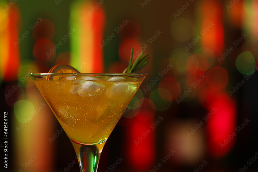 Martini glass with cocktail, ice cubes and rosemary in bar, closeup. Space for text Martini glass with cocktail, ice cubes and rosemary in bar, closeup. Space for text