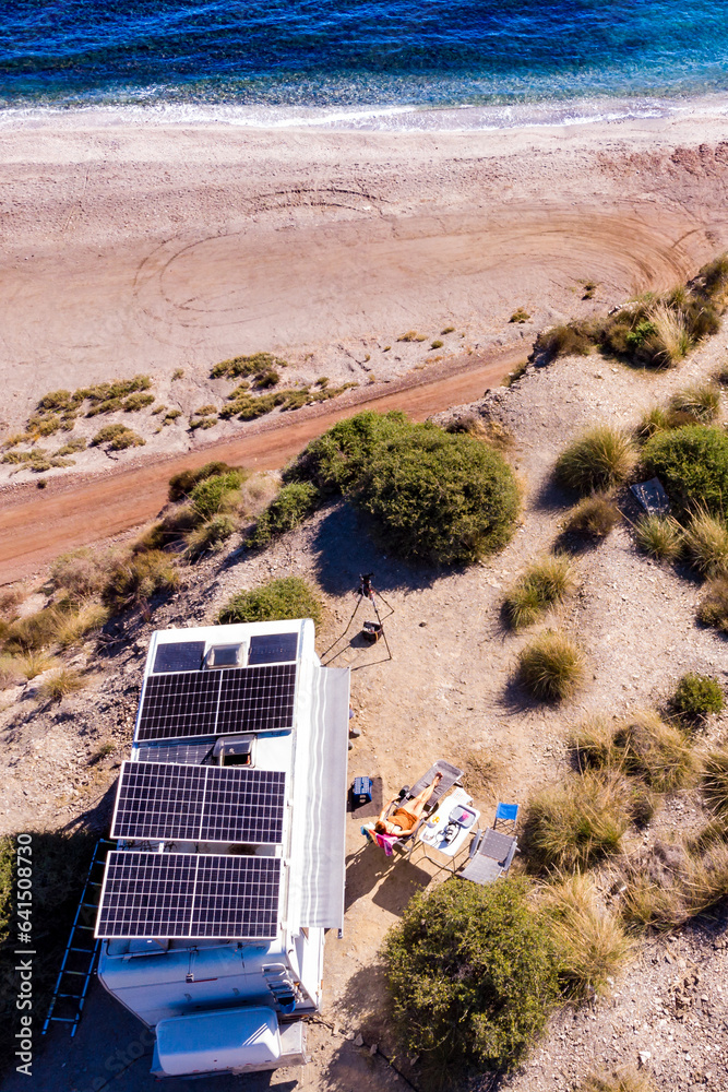 Fototapeta premium Caravan with tilt solar panels on roof. Aerial view.