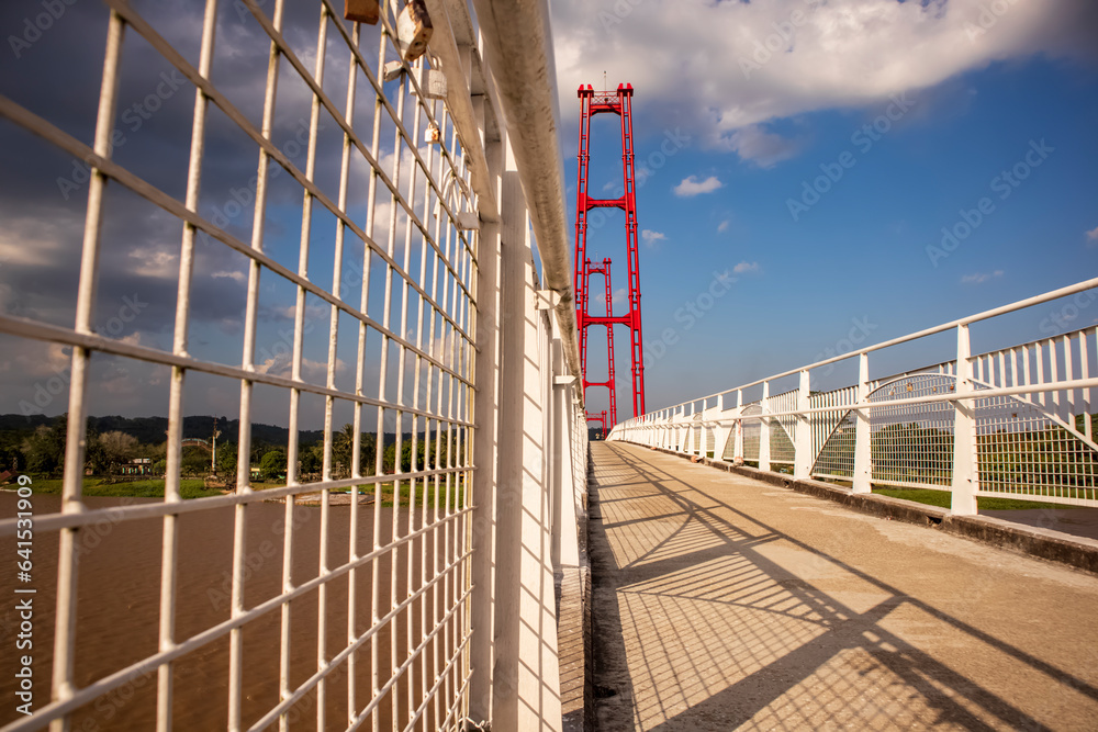Fototapeta premium Kumala Island Red Bridge which is access to one of the tourist destinations in Tenggarong City, Kutai Kartanegara Regency, namely Kumala Island.