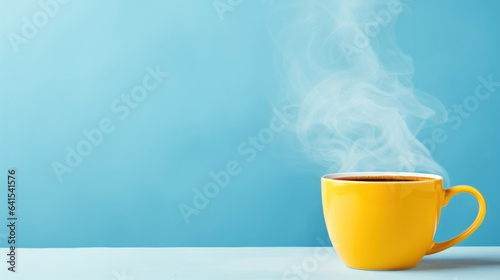 Yellow hot cup of coffee with smoke on pastel blue background, copy space