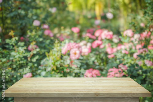 Empty wood table top with blur rose garden background for product display
