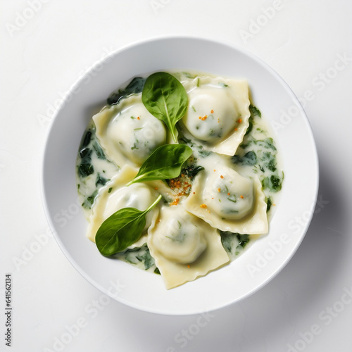 View from the top od vegan meal of spinach and ricotta ravioli pasta on a white bowl white background