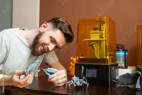 Bilde på lerret Man cutting excess plastic from 3d printer object