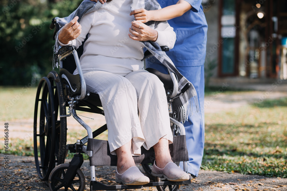 Obraz premium Asian young woman nurse at nursing home take care disabled senior man. Caregiver doctor serve physical therapy for older elderly patient to exercise and practice walking on walker or cane at backyard.