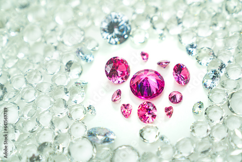 .Pink gemstones is displayed on a white background swirling around..Pink diamonds of various sizes and shapes are displayed in the middle of white diamonds..Sweet pink diamonds.white gems background.