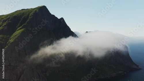 Cinematic drone shot of clouds moving over cliffs at Horseid Beach.  Northern side of Moskenesøy, in the western part of Lofoten photo