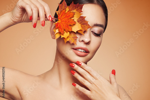 Fototapete Portrait of beautiful young woman with autumn leafs