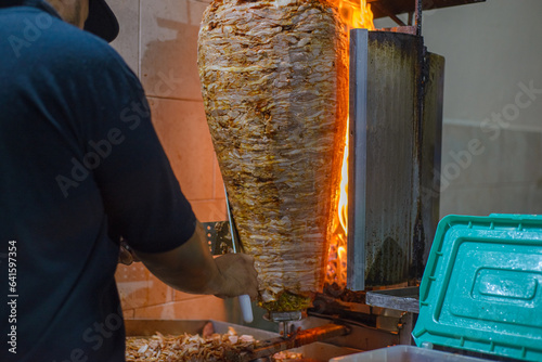 Meat trompo for tacos al pastor. Mexican street food. Marinated meat al pastor. photo