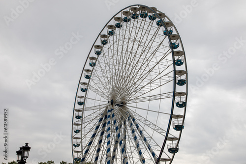 Giant ferris wheel funfair park against grey cloudy sky