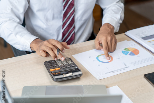 Businessman Accountant analyzing investment charts Invoice and pressing calculator buttons over documents. Accounting Bookkeeper Clerk Bank Advisor And Auditor Concept.