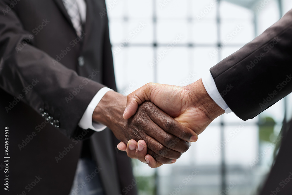 Businessmen reach out to each other to shake hands