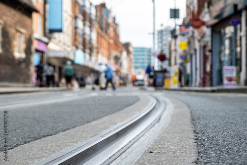 British high street shops close focused in tram tracks on the road- Croydon, South London © William