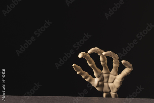 Plastic skeleton hand with copy space on black background