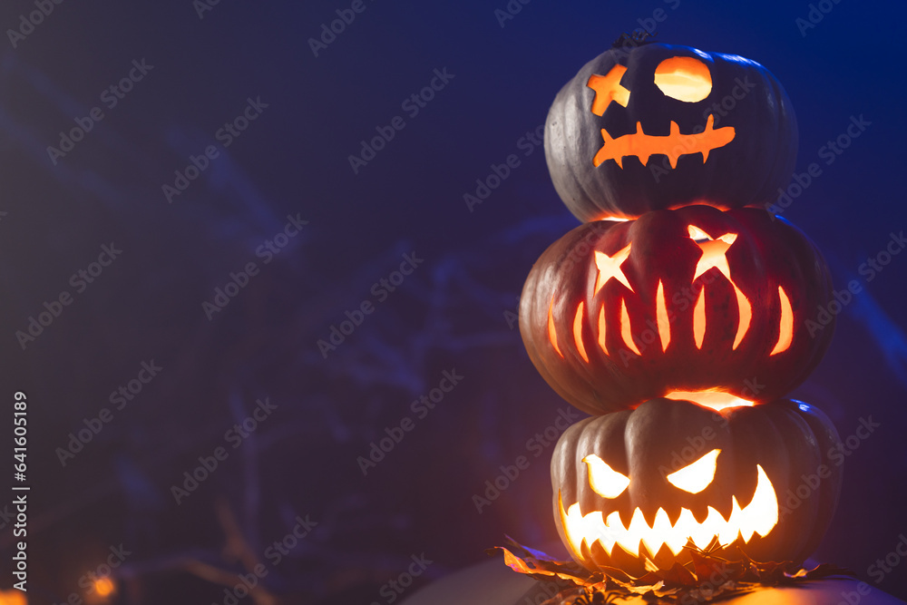 Fototapeta premium Carved pumpkins with copy space on blue background