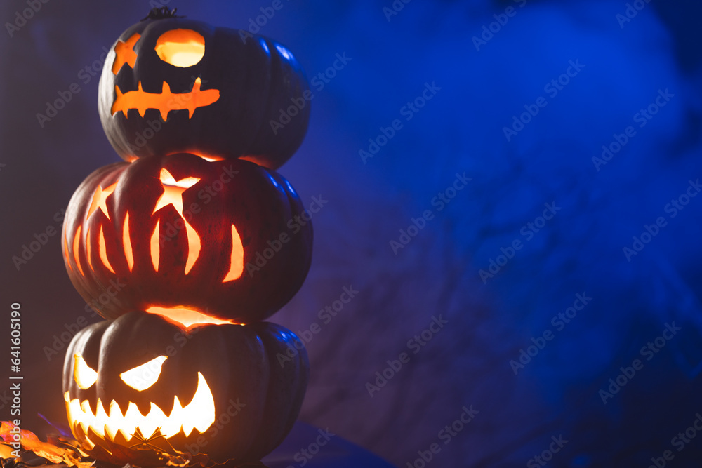 Fototapeta premium Carved pumpkins with copy space on blue background