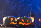 Carved pumpkins and lantern with copy space on blue background