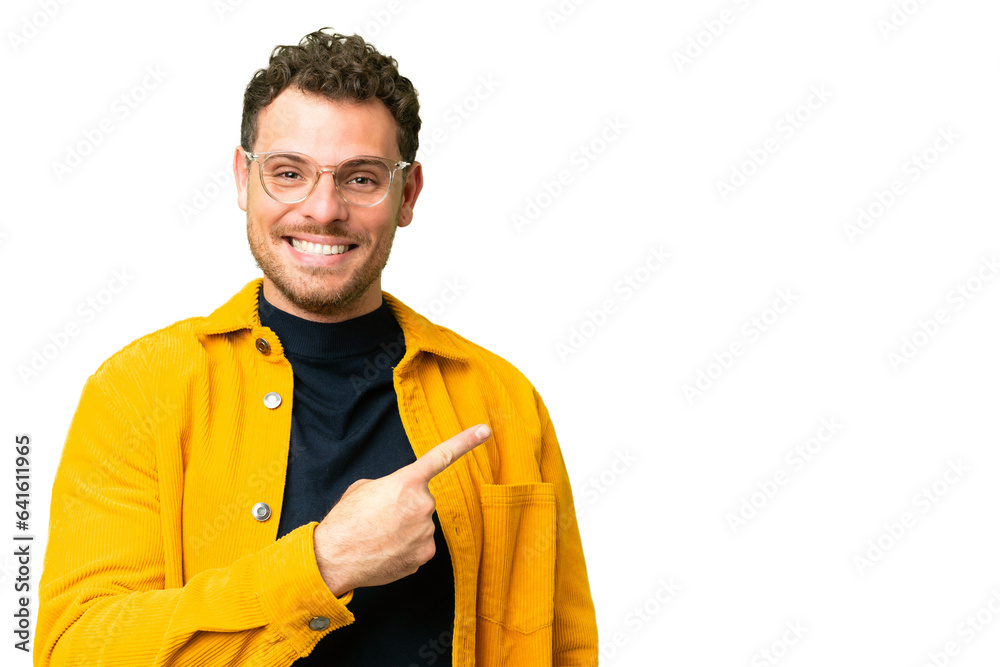 Brazilian man over isolated chroma key background pointing to the side to present a product Brazilian man over isolated chroma key background pointing to the side to present a product