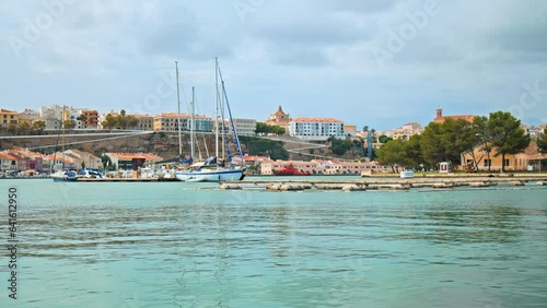 Boats and ships floating by the seashore of Mahon City in Menorca, Spain in 4K. Sea Life concept on the Balearic Islands with sailing vessels and colourful Spanish houses. photo