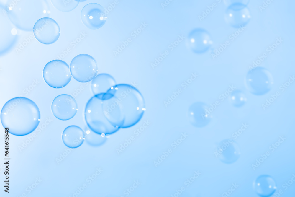 Refreshing of Soap suds, Bubbles Water. Beautiful Transparent Blue Soap Bubbles Floating in The Air. Abstract Blurred Background, Blue Textured, Celebration Festive Backdrop.