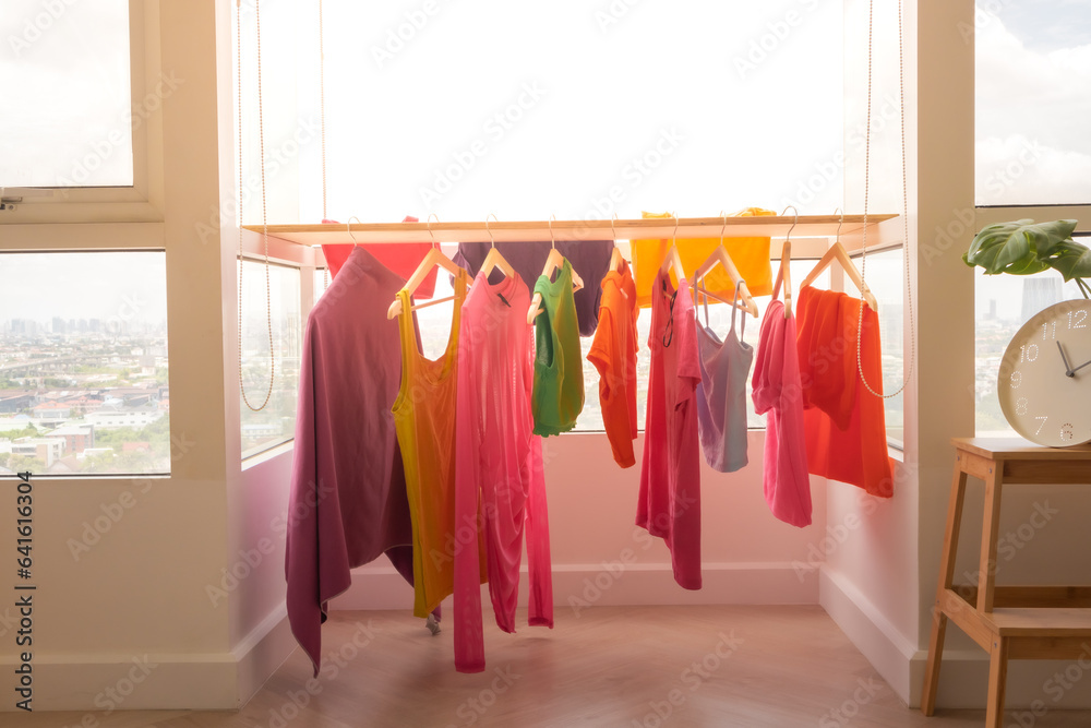 Colorful clothes hanging on the balcony dry in sun at apartment. - obrazy, fototapety, plakaty 