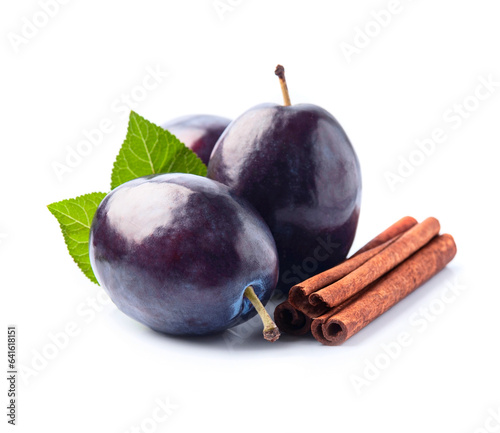 Sweet plums with cinnamon stick on white backgrounds
