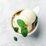 Vanilla sweet ice cream with mint ice cream spoon on a white stone background top view