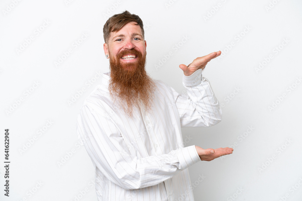 Redhead man with long beard isolated on white background holding copyspace to insert an ad Redhead man with long beard isolated on white background holding copyspace to insert an ad