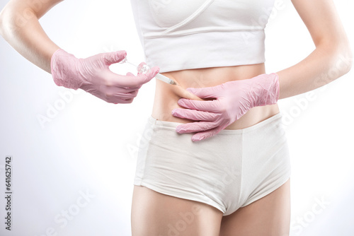Lipolytic injections for burning fat on the abdomen, legs and thighs of a woman. Women's aesthetic cosmetology in a beauty salon.