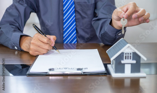 Real estate agents hand use pen explains the business contract for signing a business contract, renting, buying, mortgage, loan or home insurance