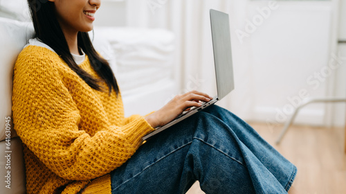 Obraz na plátně Asian woman using the smartphone, laptop and tablet on the sofa at home
